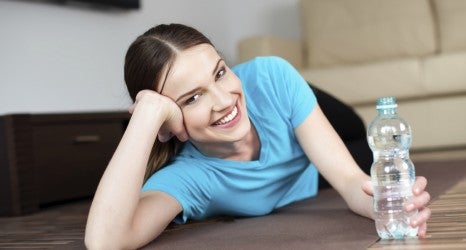 Happy young woman lying on the floor after yoga exercises